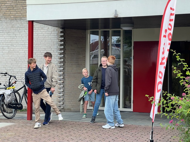 vrolijke kinderen na kerkdienst HGL bij bord 't Lichtschip